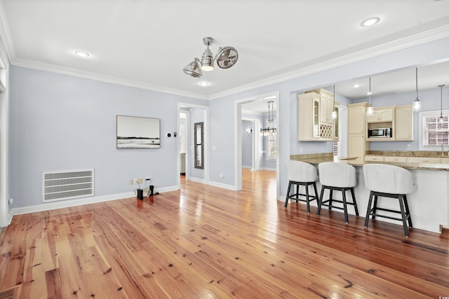 interior space featuring crown molding, light hardwood / wood-style floors, and a notable chandelier