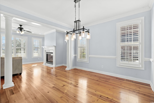 unfurnished dining area featuring plenty of natural light, ceiling fan, light wood-type flooring, and crown molding