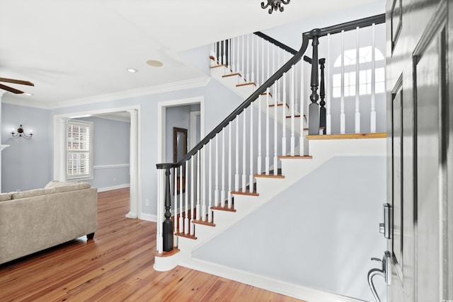 stairway featuring crown molding, ceiling fan, and hardwood / wood-style flooring