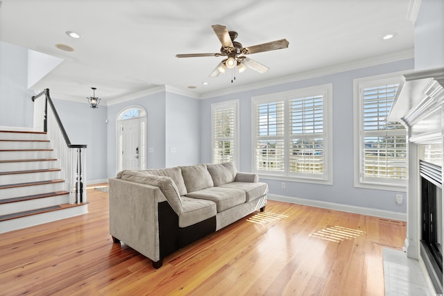 living room featuring ceiling fan, a healthy amount of sunlight, crown molding, and light hardwood / wood-style flooring