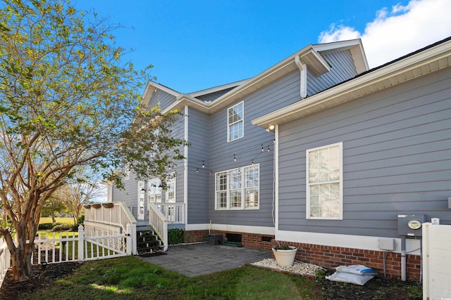 back of property featuring a deck and a patio