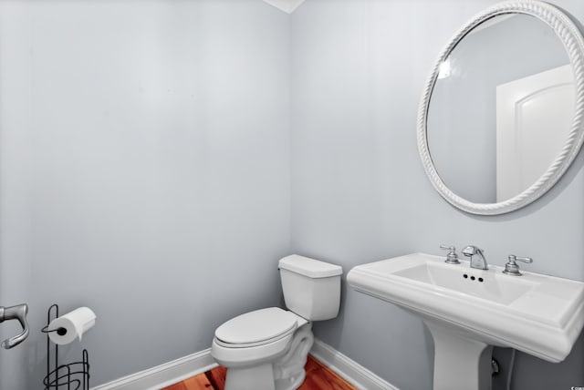 bathroom featuring wood-type flooring and toilet