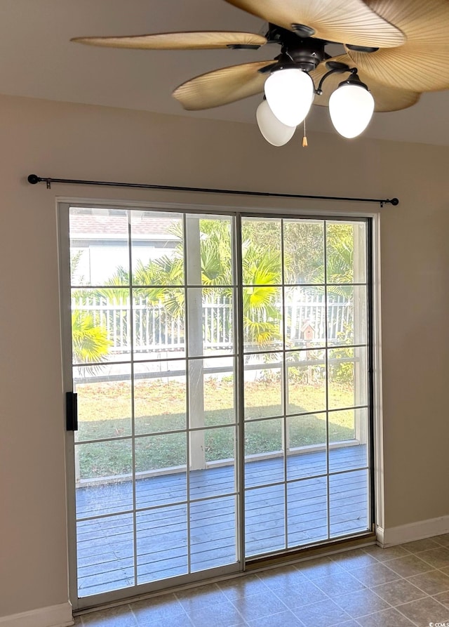 doorway with light tile patterned floors and ceiling fan