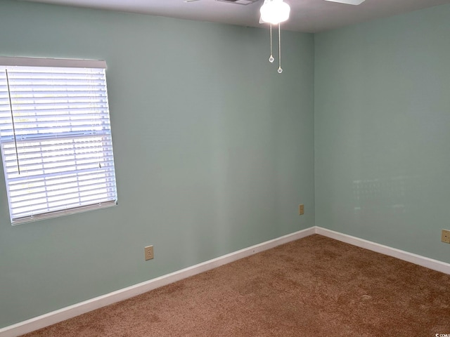 carpeted spare room featuring ceiling fan