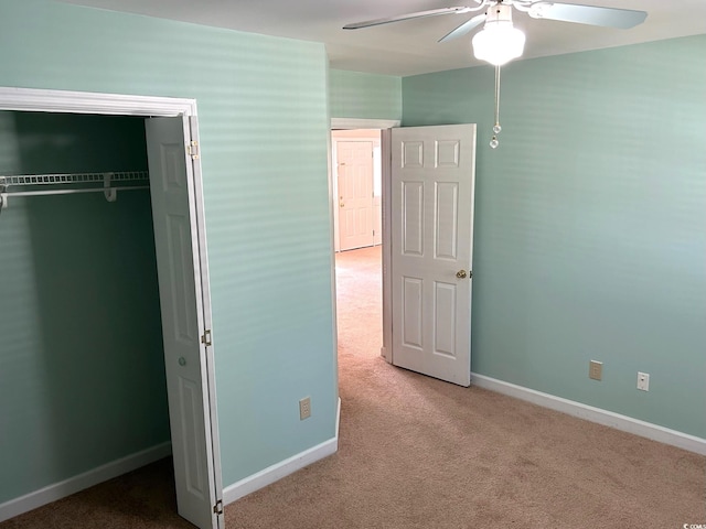 unfurnished bedroom featuring carpet floors, a closet, and ceiling fan