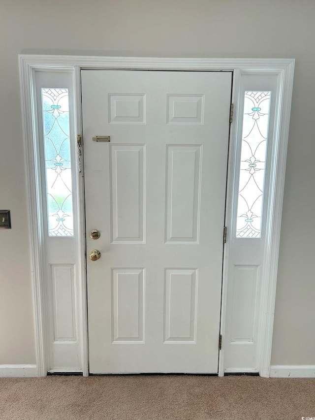 foyer featuring light carpet