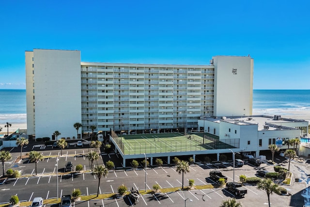 view of building exterior with a water view and a beach view