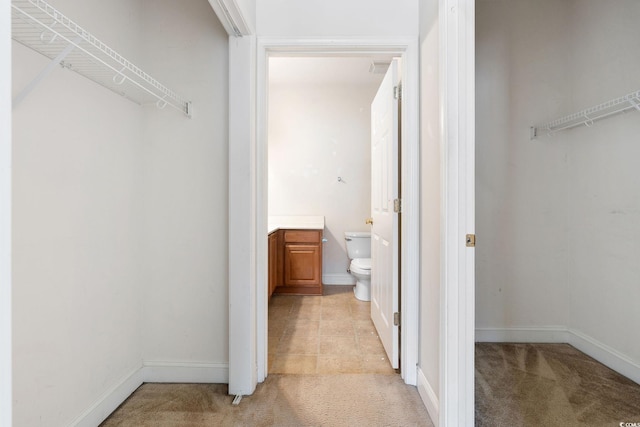 spacious closet featuring light carpet