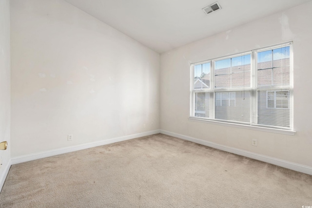 unfurnished room featuring light colored carpet and vaulted ceiling