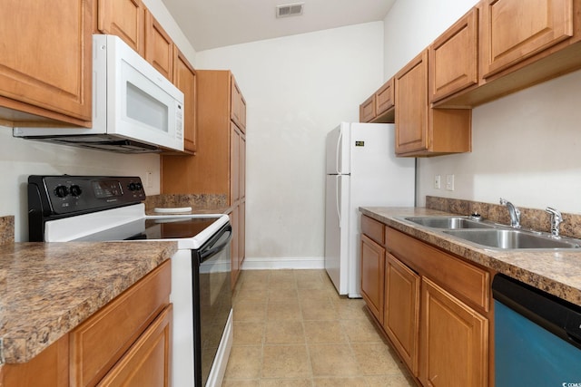 kitchen featuring lofted ceiling, sink, light tile patterned floors, and white appliances