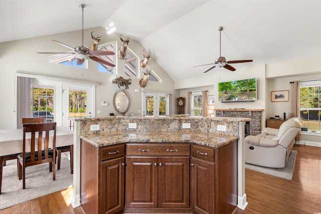 2580 Ash Little River Rd, Ash, NC 28420 - kitchen featuring ceiling fan, wood finished floors, open floor plan, light stone countertops, and high vaulted ceiling