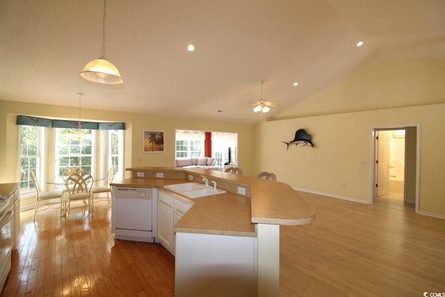 kitchen with sink, light hardwood / wood-style floors, decorative light fixtures, white appliances, and white cabinets