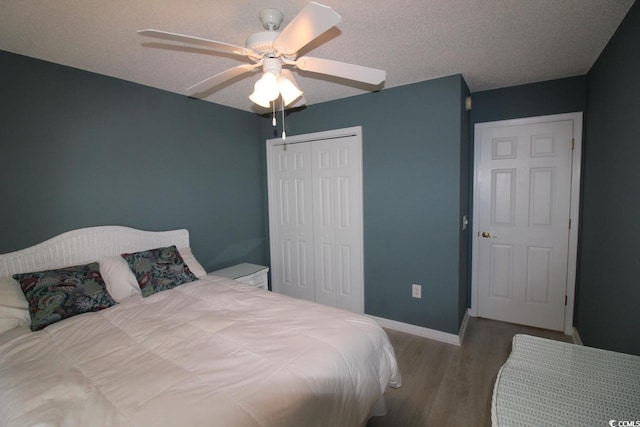 bedroom with hardwood / wood-style floors, a textured ceiling, a closet, and ceiling fan