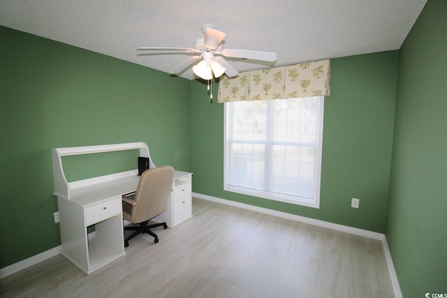 unfurnished office with ceiling fan, light wood-type flooring, and a textured ceiling