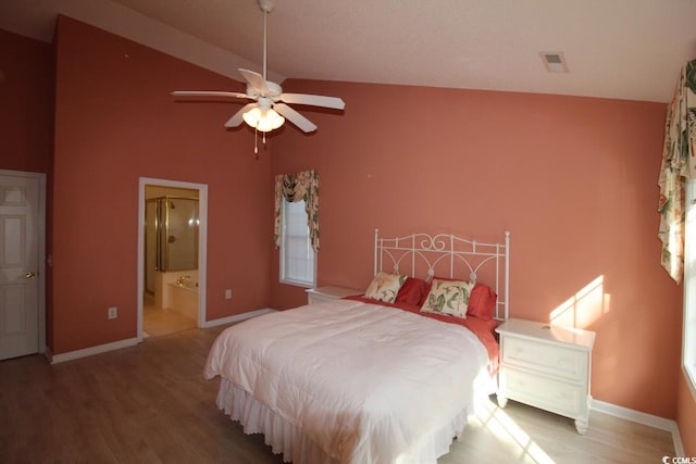 bedroom featuring ceiling fan, ensuite bathroom, high vaulted ceiling, and wood-type flooring