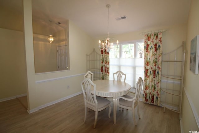 dining room with a notable chandelier and wood-type flooring