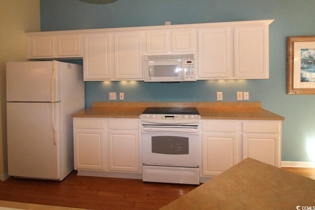 kitchen with white cabinetry, dark hardwood / wood-style flooring, and white appliances