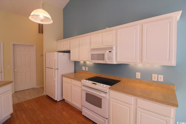 kitchen featuring light wood-type flooring, white appliances, decorative light fixtures, white cabinets, and a high ceiling