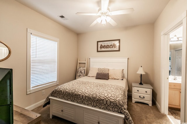 bedroom featuring ensuite bath, ceiling fan, sink, and dark colored carpet