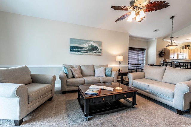 living room featuring carpet flooring, ceiling fan, and ornamental molding