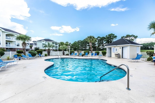 view of pool with a patio and an outdoor structure