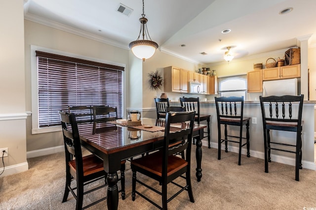 dining area featuring light carpet and crown molding