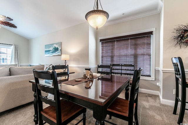 carpeted dining room with crown molding and vaulted ceiling