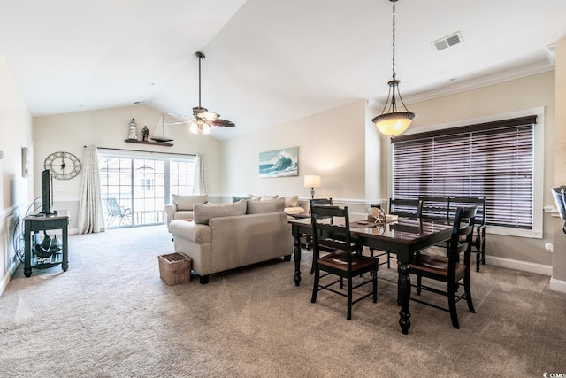 carpeted dining space featuring ceiling fan, vaulted ceiling, and ornamental molding