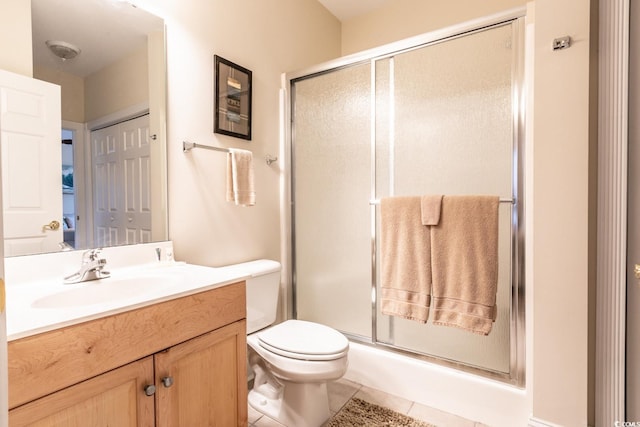 bathroom featuring tile patterned floors, vanity, and a shower with shower door