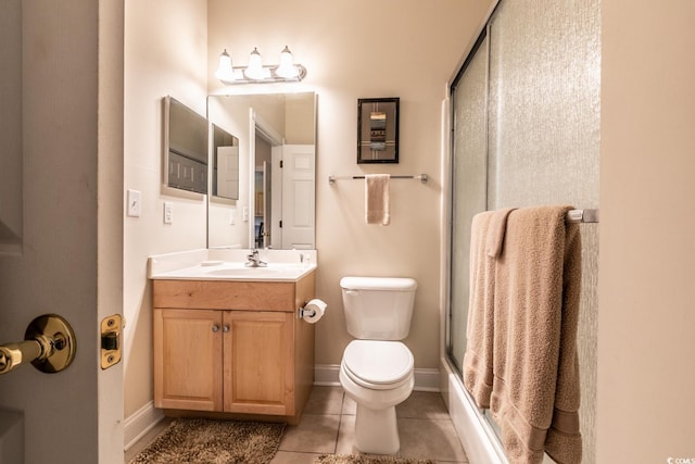 bathroom featuring tile patterned floors, vanity, toilet, and walk in shower