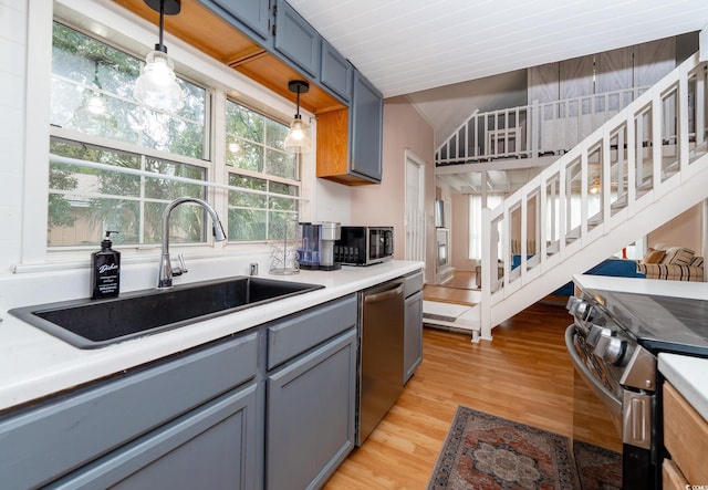 114 N Pinewood Dr N, Surfside Beach, SC 29575 - kitchen with light wood finished floors, stainless steel appliances, hanging light fixtures, light countertops, and a sink