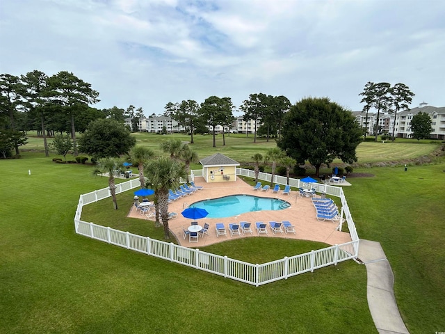 view of pool with a lawn and a patio