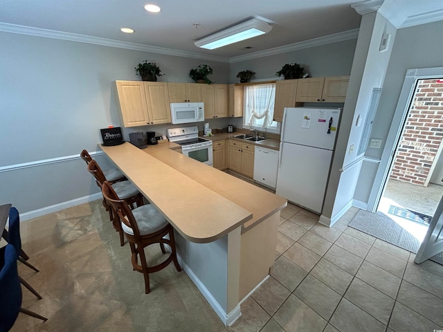 kitchen featuring kitchen peninsula, ornamental molding, a breakfast bar, white appliances, and sink