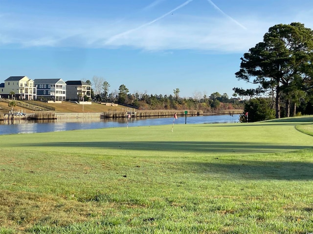 view of home's community featuring a lawn and a water view