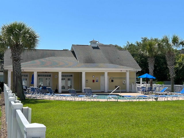 rear view of property featuring ceiling fan, a patio area, a yard, and french doors