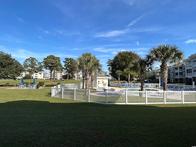 surrounding community with a lawn and a pool