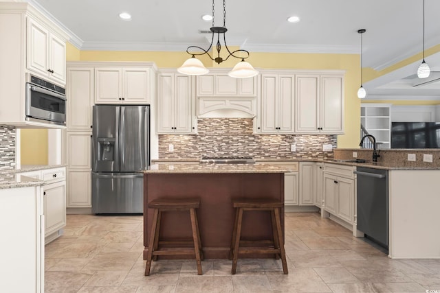 kitchen with pendant lighting, sink, a breakfast bar, appliances with stainless steel finishes, and light stone countertops