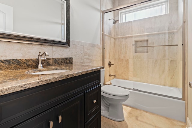 full bathroom with vanity, tile walls, enclosed tub / shower combo, and toilet