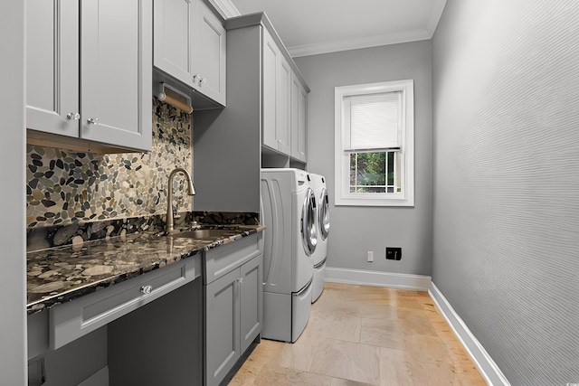 laundry room with cabinets, ornamental molding, sink, and washer and dryer