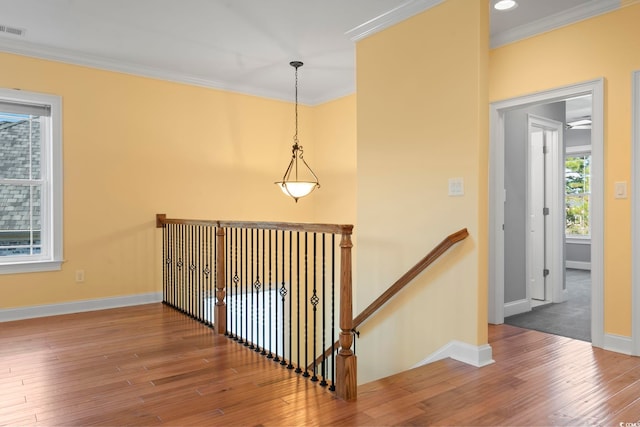 stairway featuring crown molding and hardwood / wood-style flooring