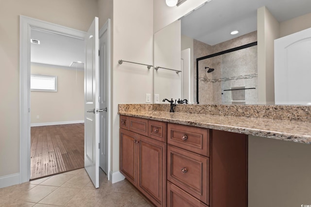 bathroom featuring tile patterned floors, an enclosed shower, and vanity