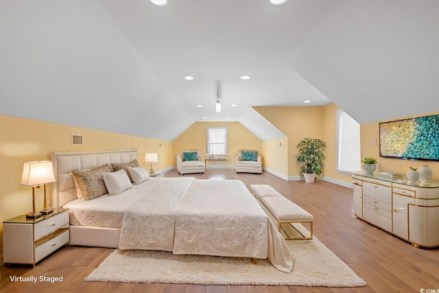 bedroom with lofted ceiling and light wood-type flooring