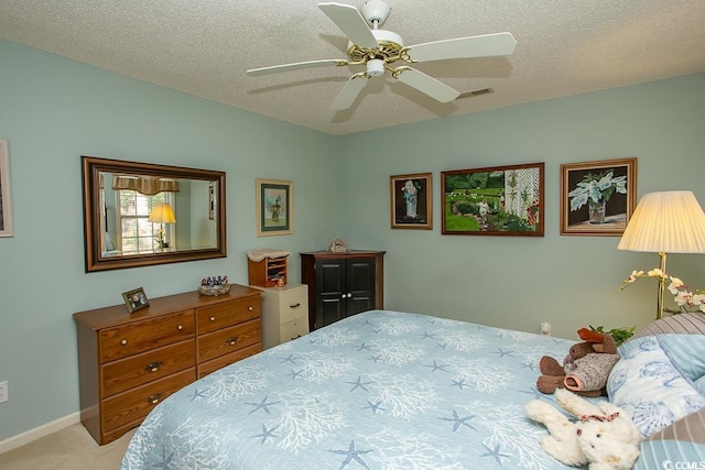 bedroom featuring a textured ceiling, ceiling fan, and light carpet