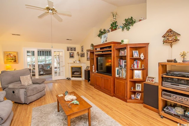 living room featuring high vaulted ceiling, light hardwood / wood-style flooring, and ceiling fan