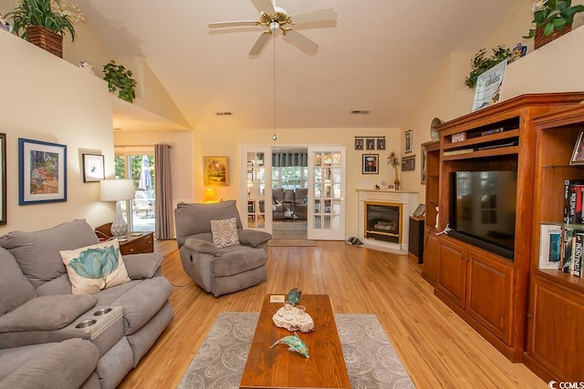 living room featuring high vaulted ceiling, light hardwood / wood-style flooring, and ceiling fan