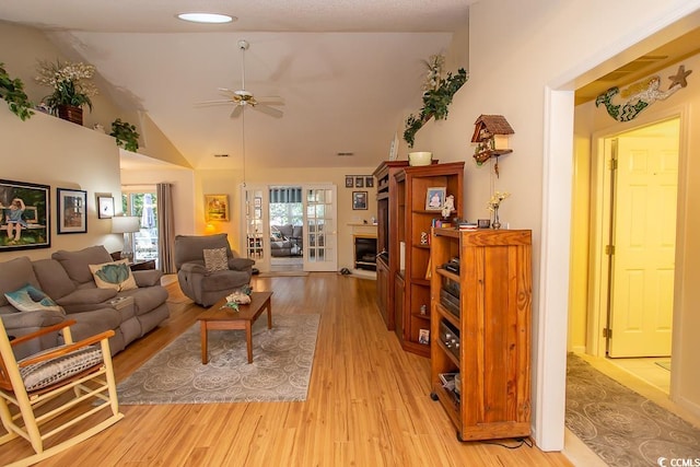 living room featuring light wood-type flooring, vaulted ceiling, and ceiling fan