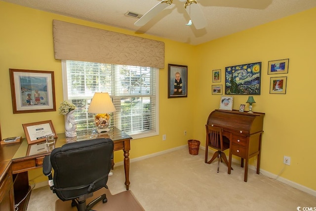 carpeted office space featuring ceiling fan and a textured ceiling