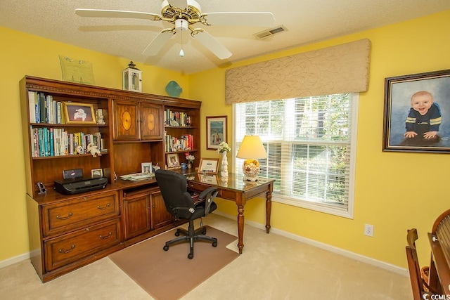 carpeted home office featuring ceiling fan and a textured ceiling