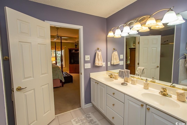 bathroom with tile patterned flooring, a textured ceiling, vanity, and ceiling fan