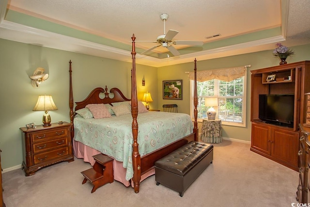 carpeted bedroom featuring a tray ceiling, ceiling fan, and crown molding